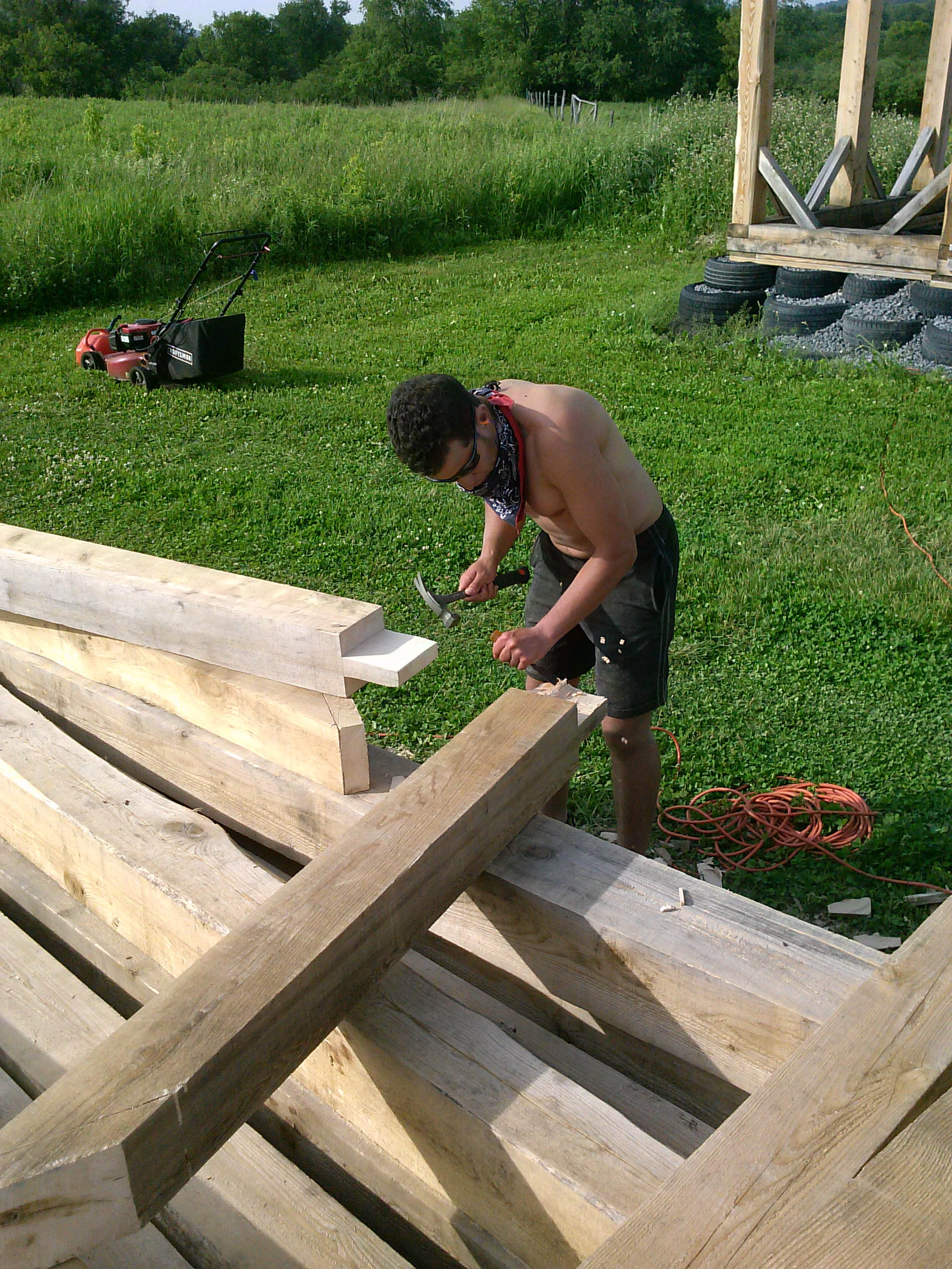 Permaculture intern working on construction on the timber framed barn