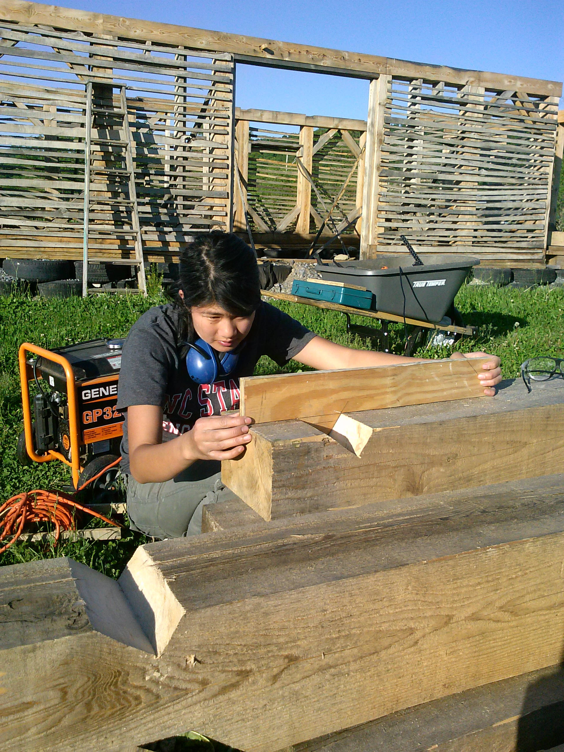 Intern working on construction of timber-framed barn